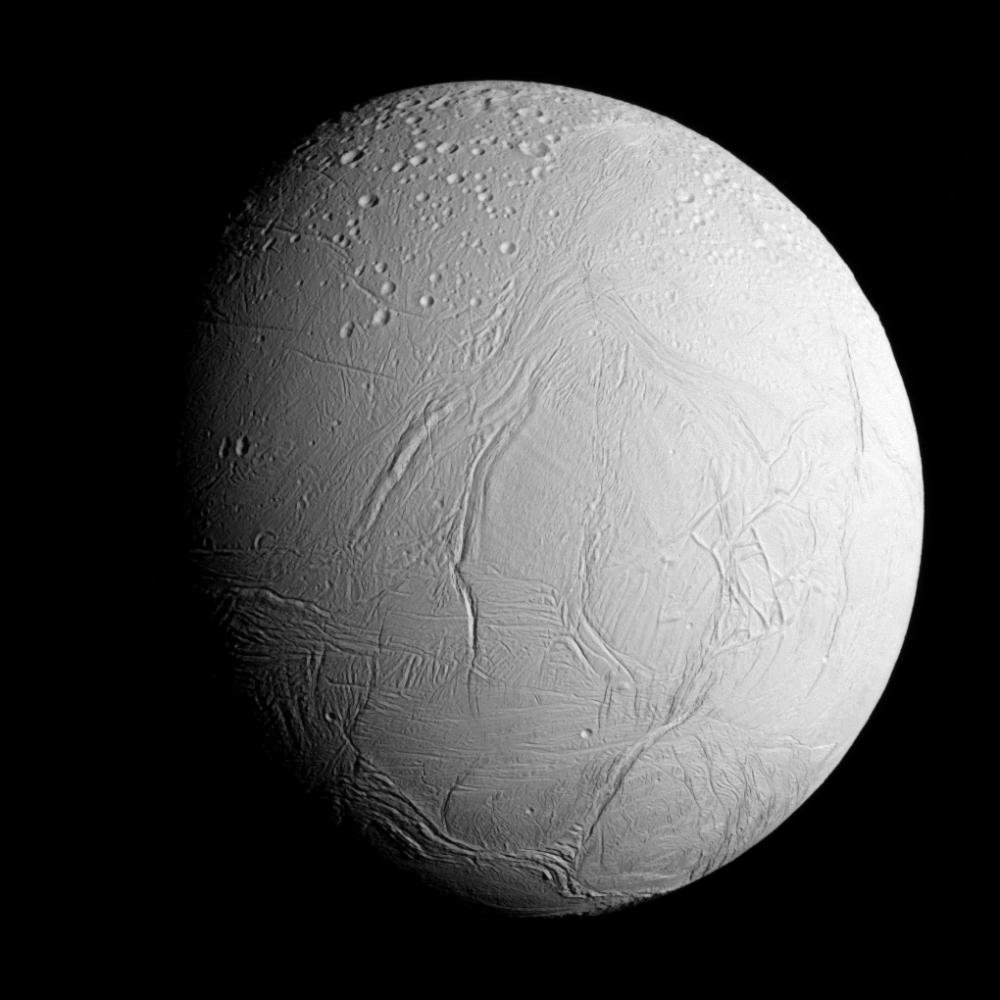 Enceladus med äldre kraterterräng i norr och yngre, slätare isytor söderut. Image credit: NASA/JPL-Caltech/Space Science Institute